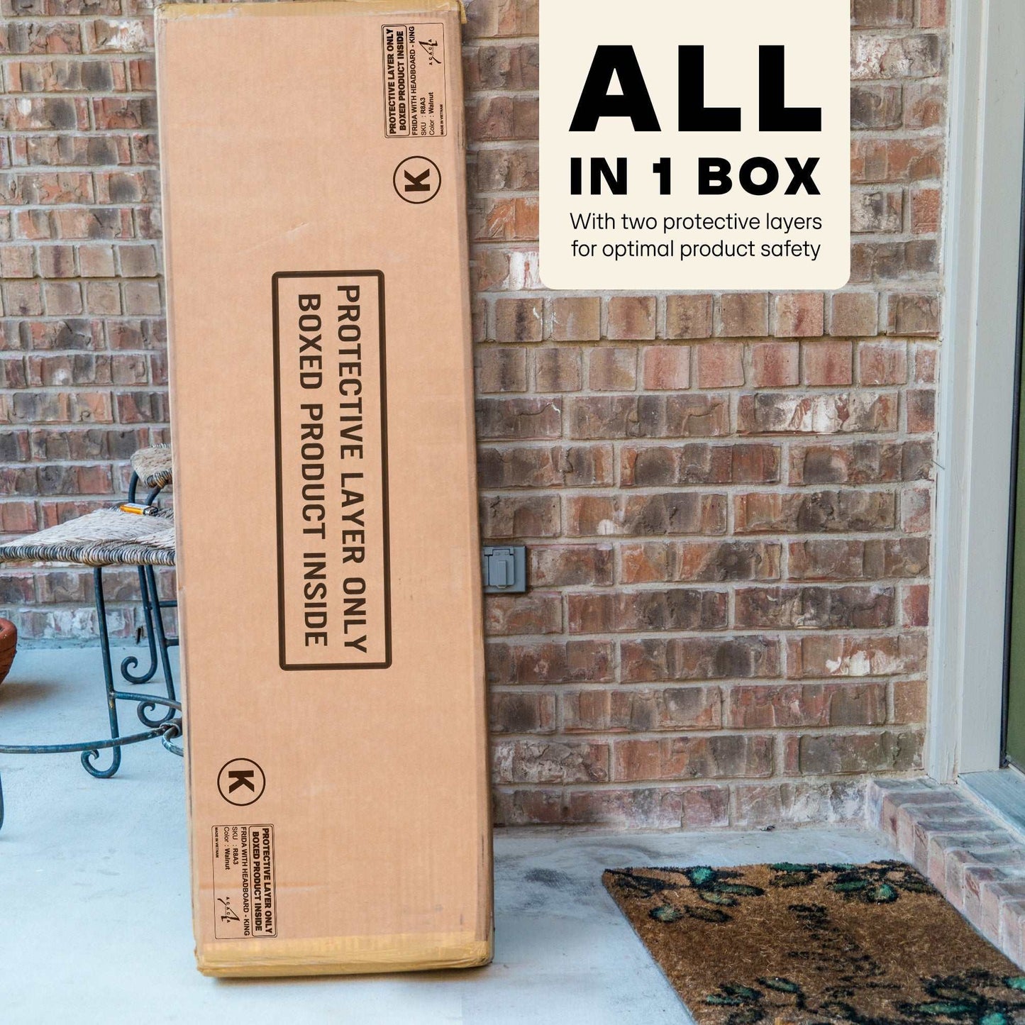 Large cardboard box with text on a doorstep against a brick wall.