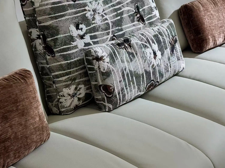 Close-up of a beige sofa with patterned and solid color cushions.