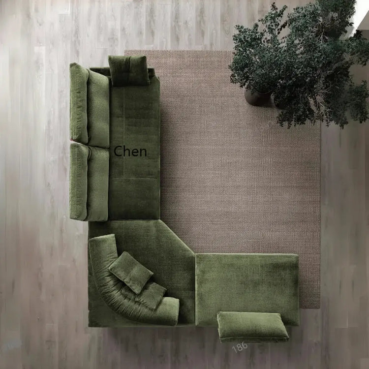 Green velvet sofa set against a textured wall with a plant.
