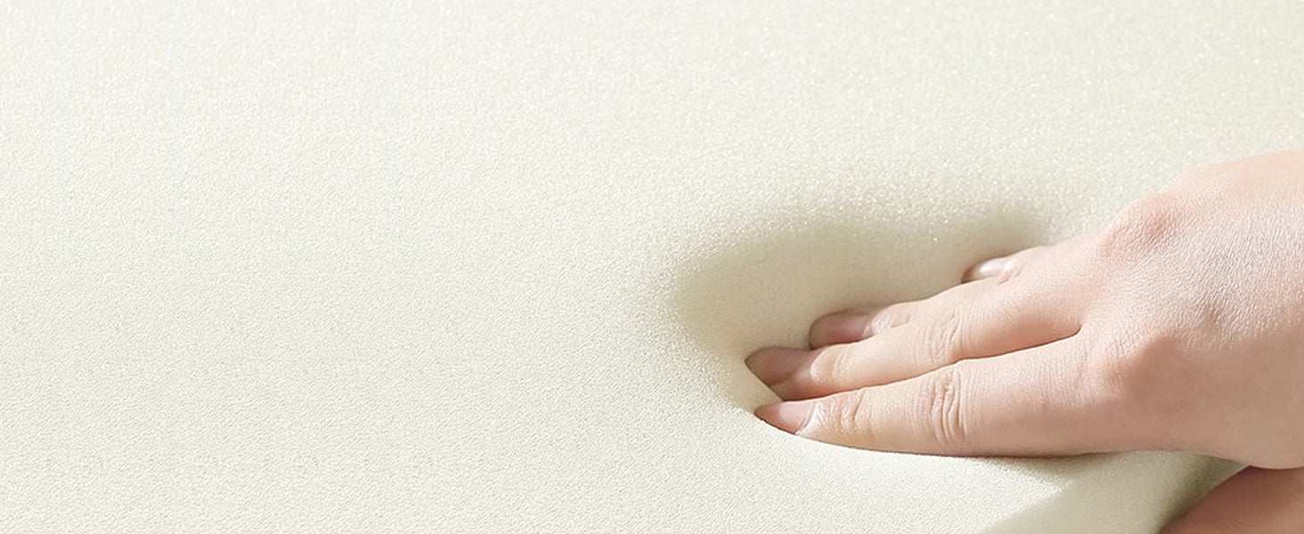 Hand pressing into a soft, white mattress surface