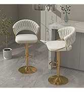 Two white bar stools with gold bases on a gray floor.