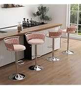 Three pink bar stools with metal legs in a kitchen setting.