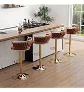 Three bar stools with woven seats and gold bases in a kitchen setting.