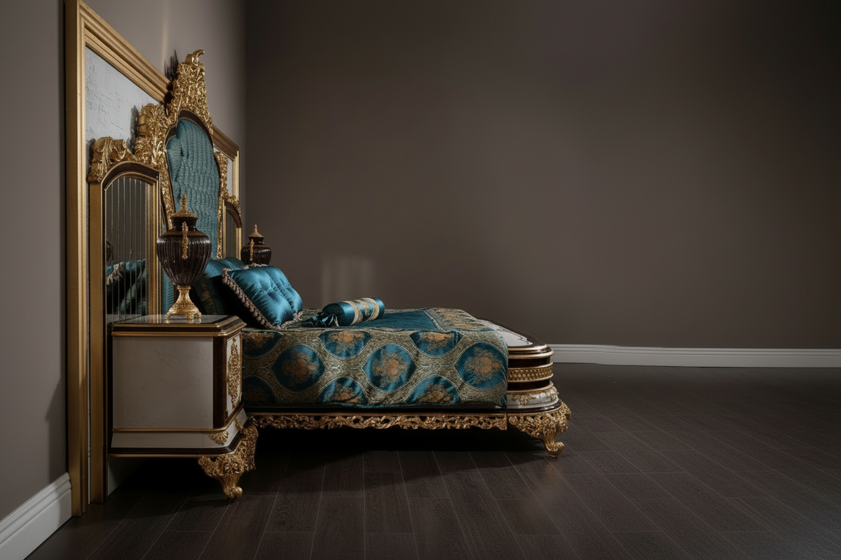 Side view of an ornate luxury bed with a carved gold frame and teal blue patterned bedding, styled in a dark, elegant bedroom with a matching nightstand and mirror.