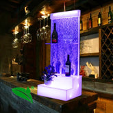 illuminated bar with wine bottles and glasses in a dimly lit room