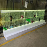 Futuristic glass display case with LED lighting and decorative elements on a concrete floor.