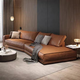 Brown leather sectional sofa in a modern living room with decor elements.