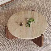 Round stone table with wooden legs on a textured surface