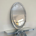 Round mirror with decorative frame on a white wall