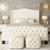 Luxurious bedroom with tufted white bed and matching ottomans.