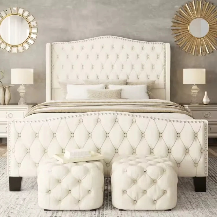Luxurious bedroom with tufted white bed and matching ottomans.