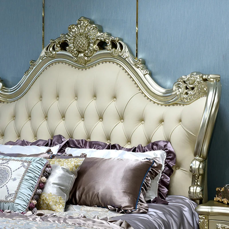 European style solid wood bed headboard with tufted cream upholstery and ornate gold details.