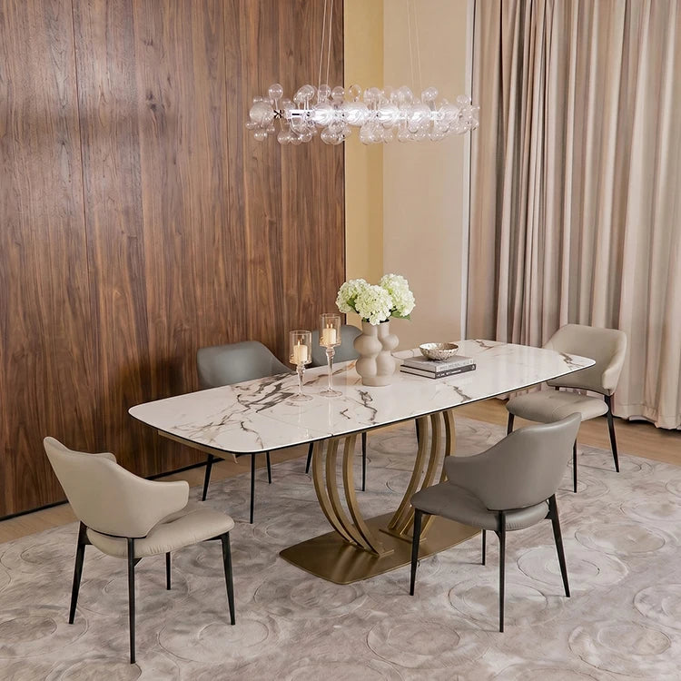 Extendable sintered stone dining table with metal frame, set for six, featuring elegant decor and modern lighting.