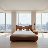 Modern bedroom with a large bed and cityscape view