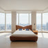 Modern bedroom with a large bed and cityscape view