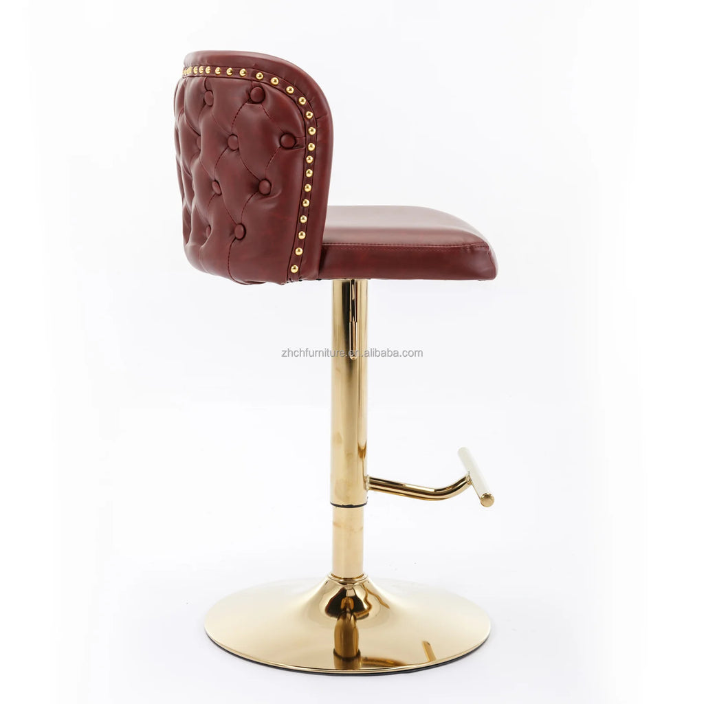 Leather Swivel Adjustable Bar Stools in tufted burgundy PU leather with gold base and nailhead trim.
