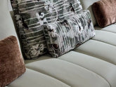 Close-up of a beige sofa with patterned and solid color cushions.