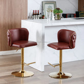 Two brown leather bar stools with gold metal legs in front of a kitchen counter.