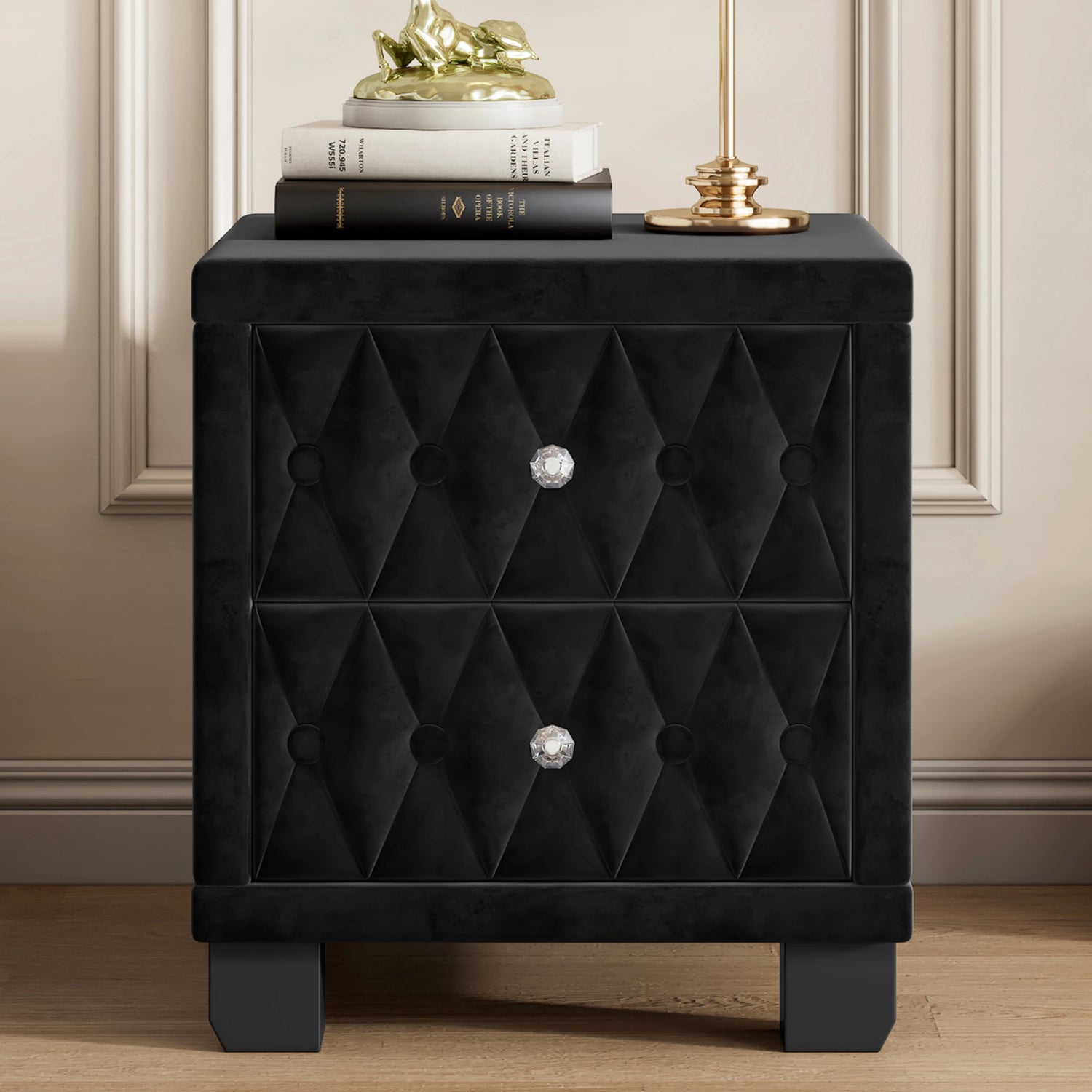Black tufted nightstand with decorative knob on a wooden floor.