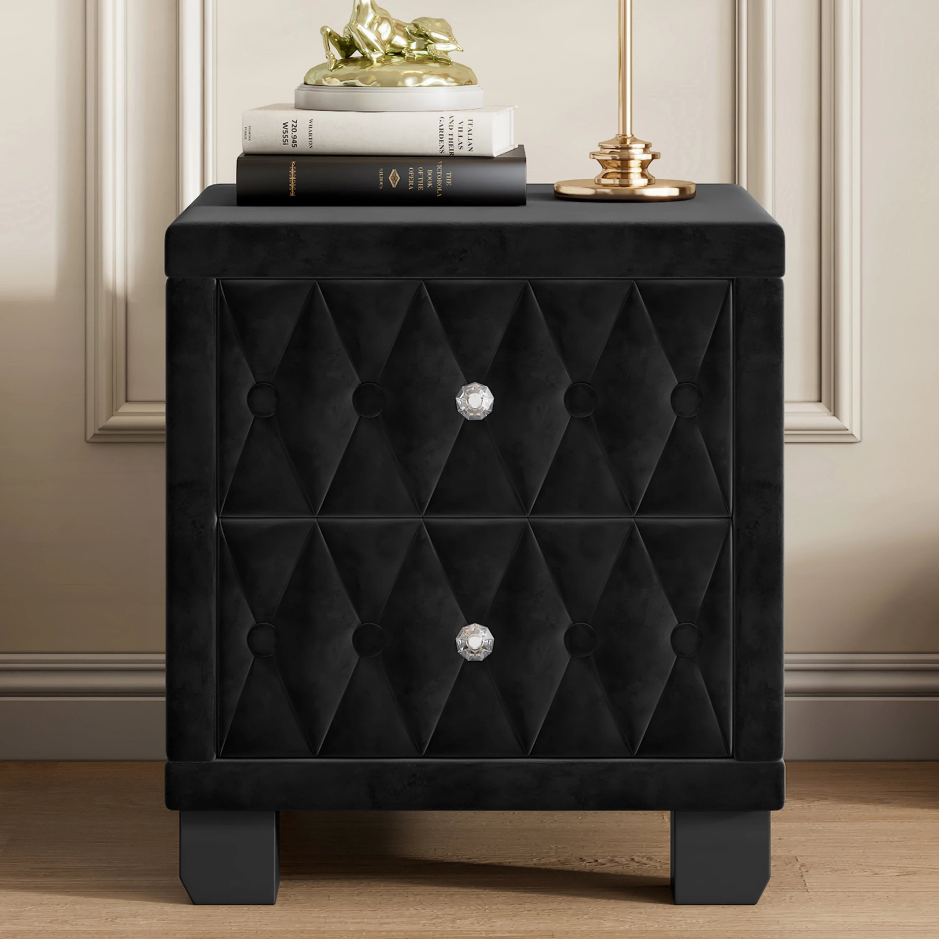 Black tufted nightstand with decorative knob on a wooden floor.