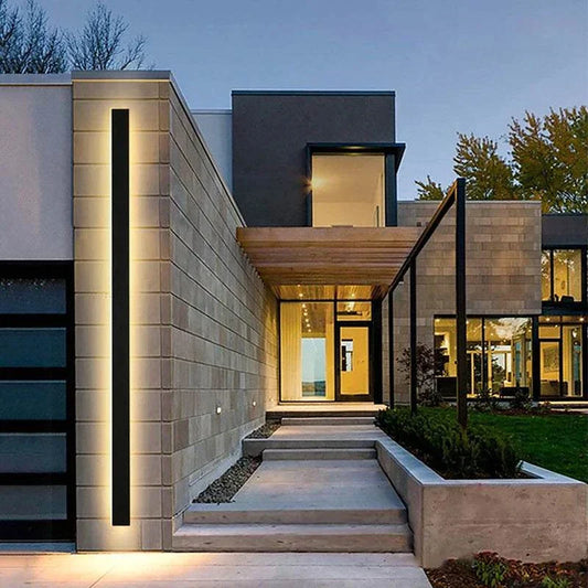 modern LED outdoor wall light on contemporary home exterior at dusk