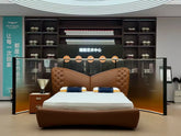 Brown leather bed with white mattress in a showroom setting