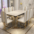 Dining table set with white chairs and gold accents in a modern interior.