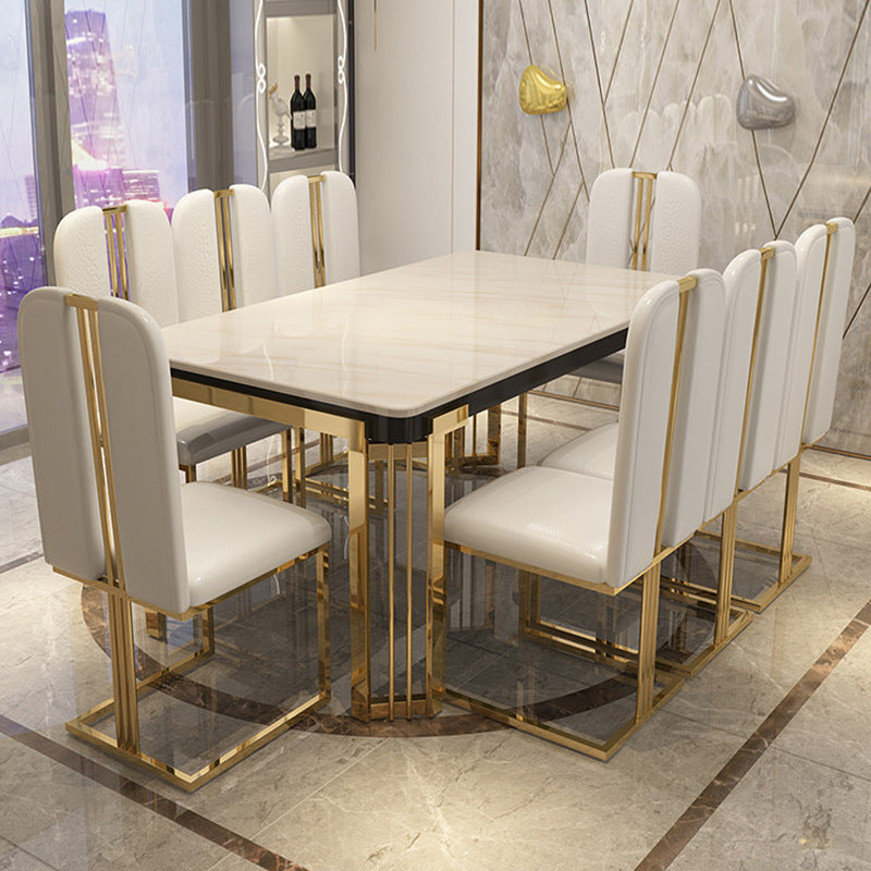 Dining table set with white chairs and gold accents in a modern interior.