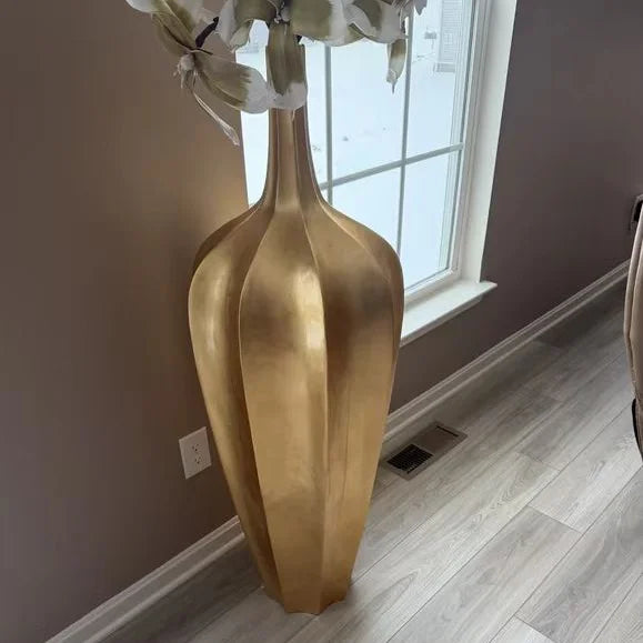 Gold plated oversized decorative vase showcasing luxury and opulence in a modern home setting.