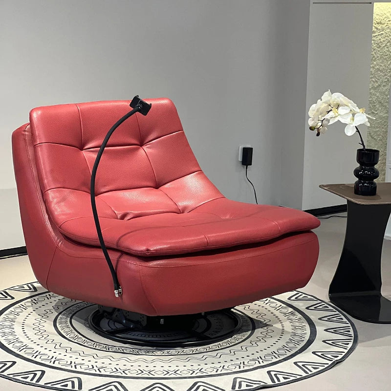 A red leather swivel lounge chair with a black gooseneck floor lamp draped over it, set on a patterned round rug in a modern room next to a side table with a white orchid.