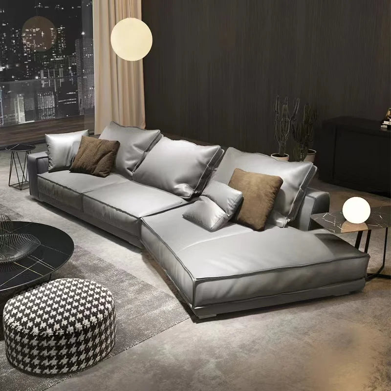 Italian minimalist leather sectional sofa in gray featuring cushions and modern design.