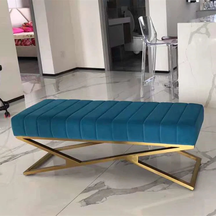 Modern tufted velvet bench in teal with gold base, adding elegance to any interior space.