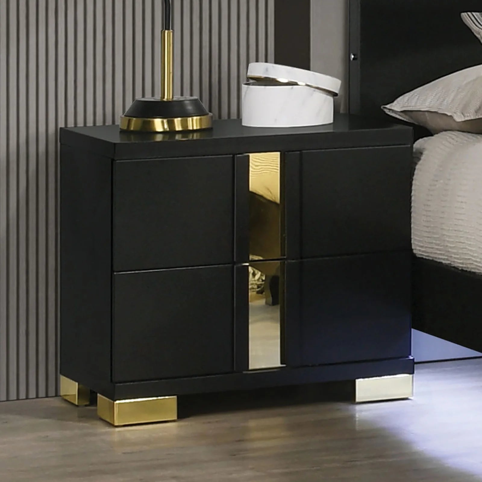 Stylish black and gold nightstand from modern king bedroom set with LED lighting in a contemporary bedroom.