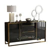 Modern black and gold sideboard with decorative items on a white background