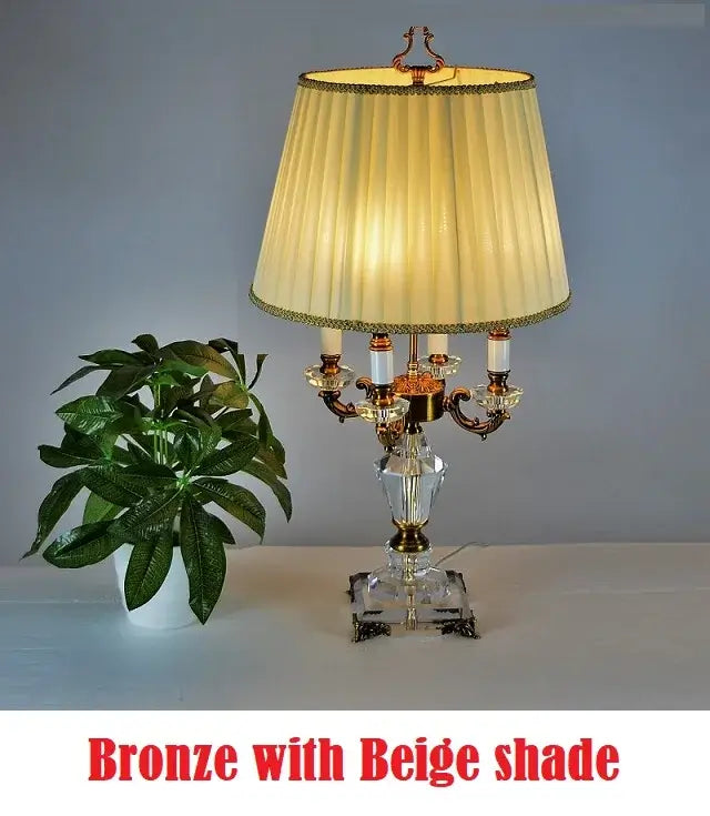 K9 crystal table lamp with fabric shade displayed beside a green plant, showcasing elegance and style.