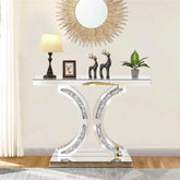 Decorative console table with a lamp, statues, and plant against a wall with a decorative mirror.