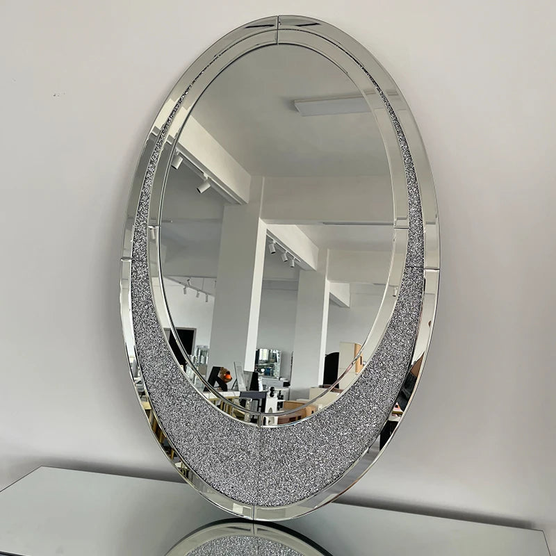 Round mirror with decorative frame on a white wall
