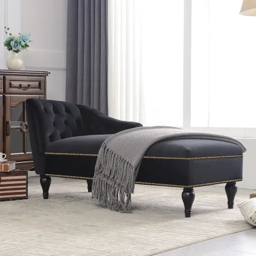 Black upholstered chaise lounge with a gray blanket in a living room setting.