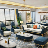 Modern living room with blue and white furniture, decorative pillows, and a chandelier.