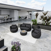 Modern outdoor patio with black furniture, plants, and a building in the background