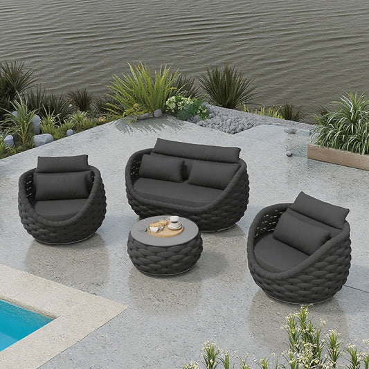 Outdoor patio set with gray chairs and a table by a poolside.