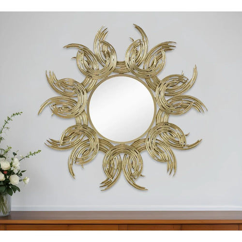 Decorative wall mirror with sunburst design on a white wall.