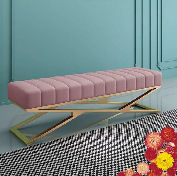 Modern tufted velvet bench with a stainless steel base in a stylish living room setting.