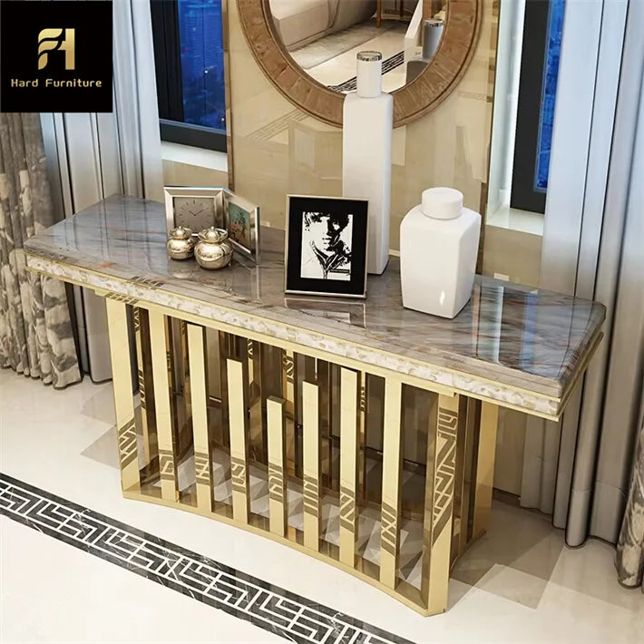 Gold stainless steel marble console table in modern entryway with decorative items.