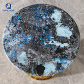 Round marble table with blue and gray pattern on a gray surface, featuring the brand &