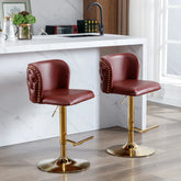 Two red bar stools with gold bases in a kitchen setting.