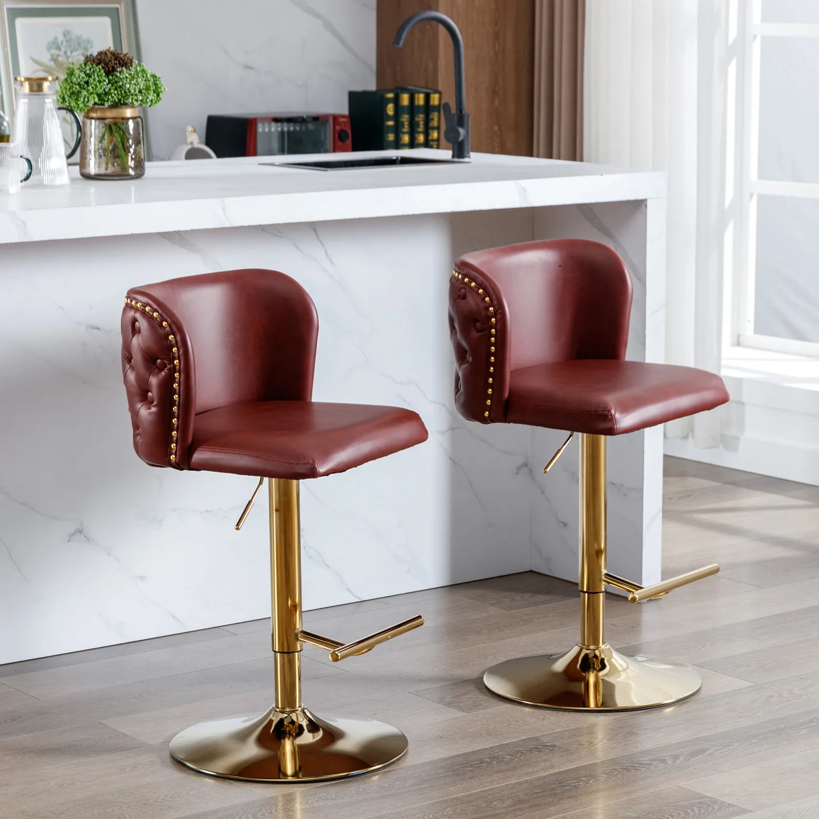 Two red bar stools with gold bases in a kitchen setting.