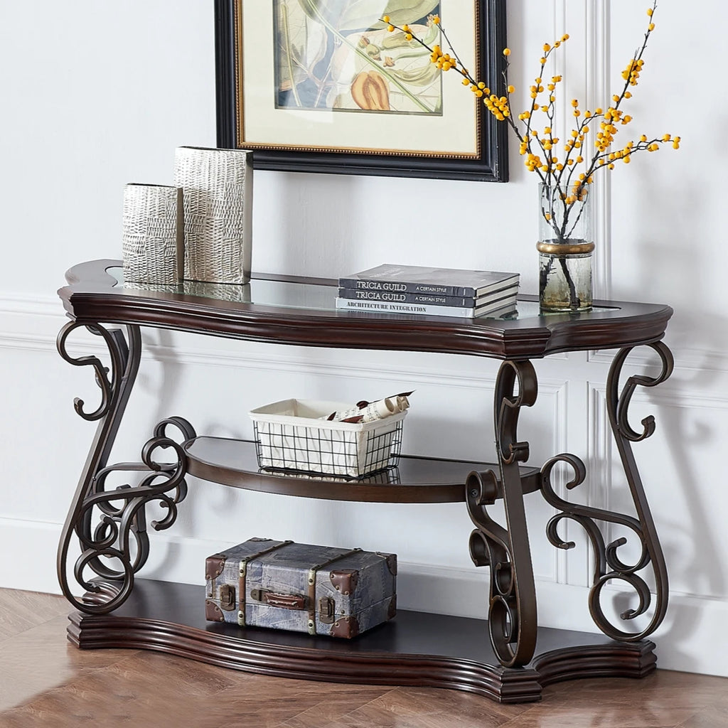 Elegant console table with ornate metal frame, glass top, and decorative items, perfect for home decor.