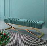 Teal velvet bench with gold metal frame against a teal wall.