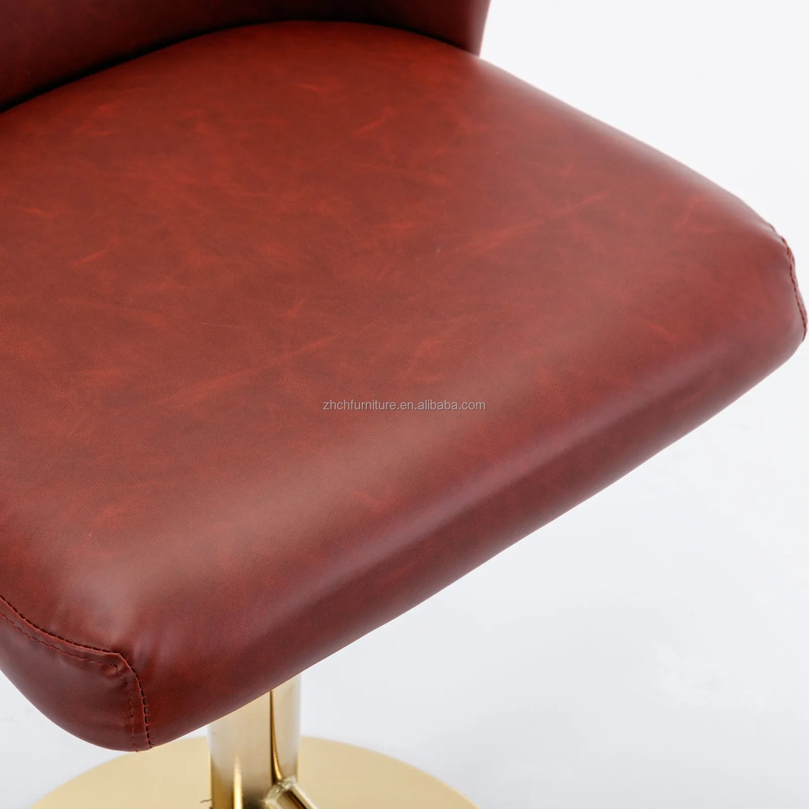 Close-up of Leather Swivel Adjustable Bar Stools with tufted PU leather seat and golden base.